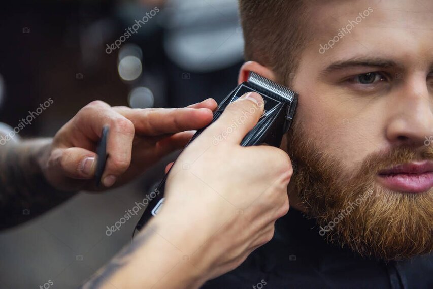 Barbier arbeitet mit Haarschneidemaschine an den Seiten